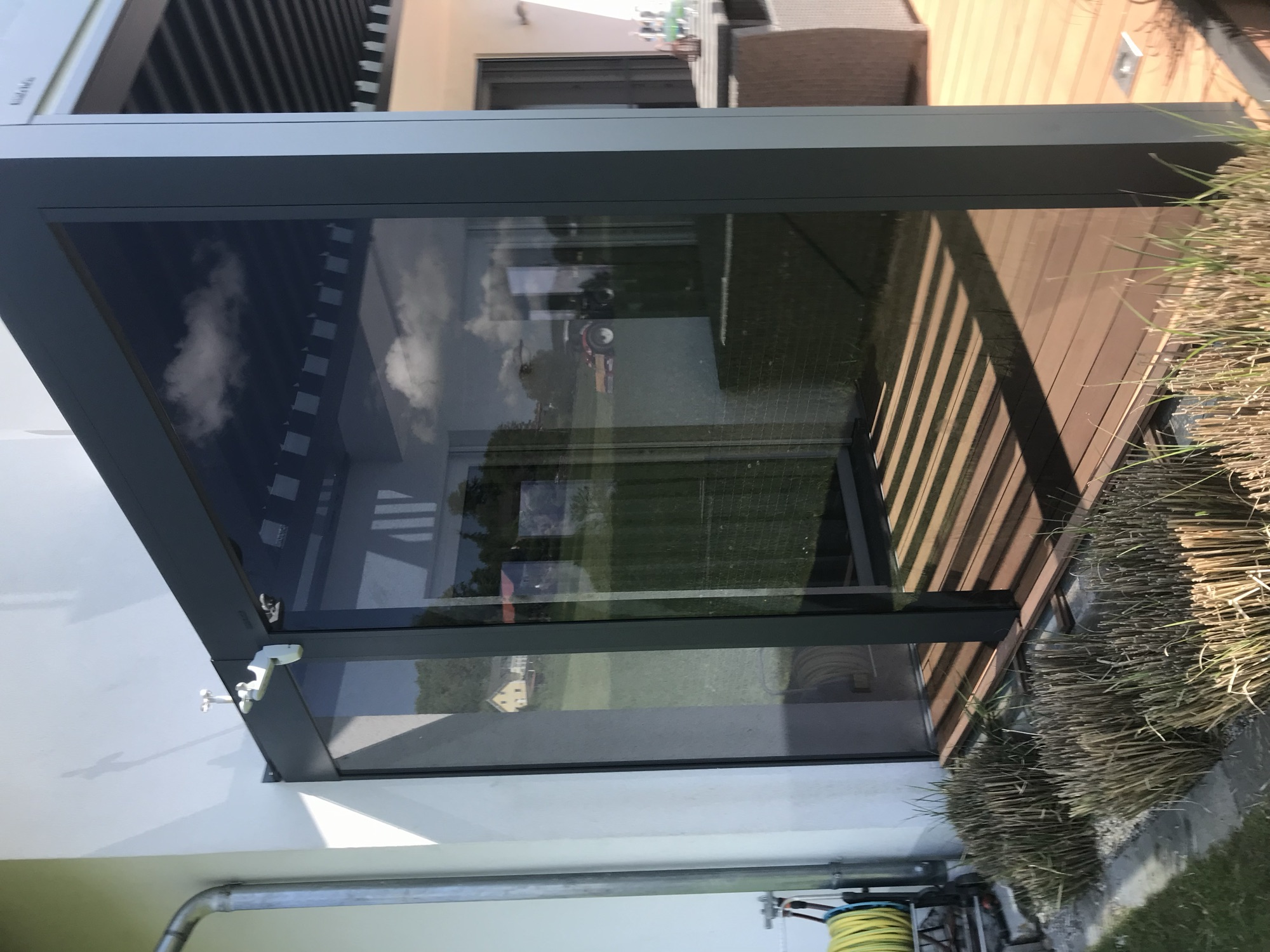Windschutz-Element aus Glas und Metall auf einer Terrasse